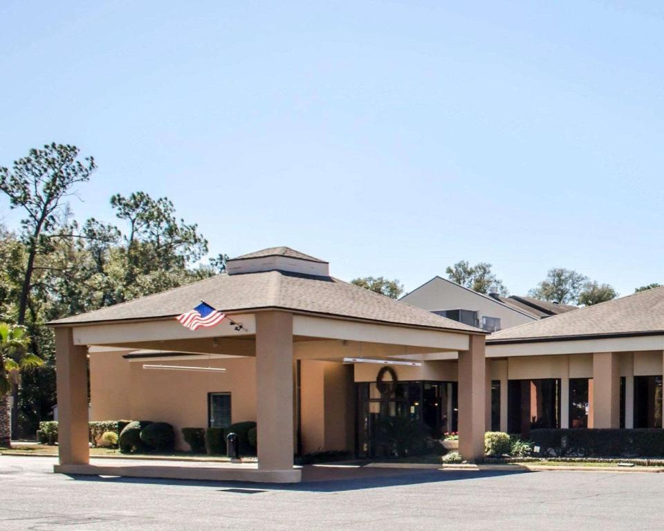 Um edifício com uma bandeira americana à frente. em Quality Inn & Suites Pensacola Bayview em Pensacola