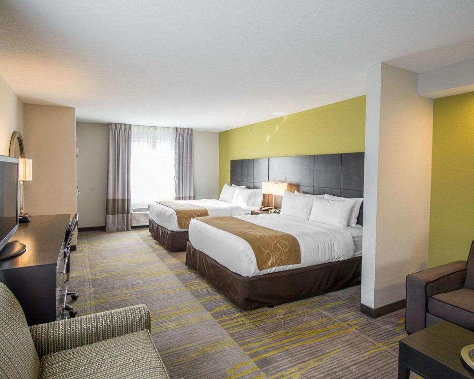 a hotel room with two beds and a television at Comfort Suites Miami Airport North in Miami
