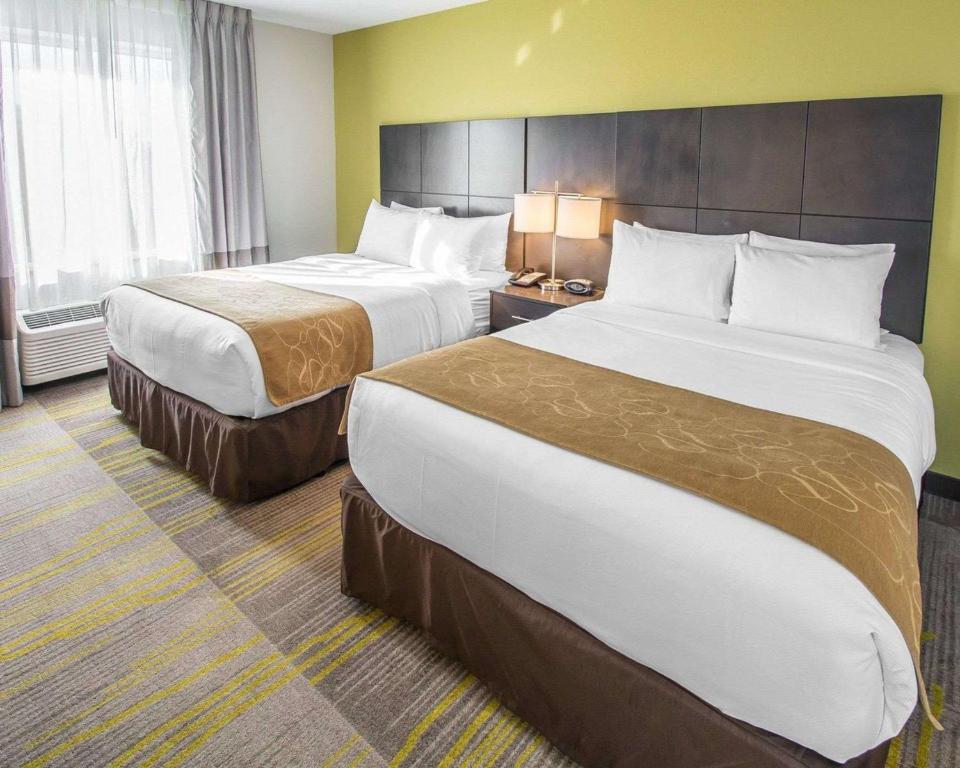 a hotel room with two beds and two lamps at Comfort Suites Miami Airport North in Miami