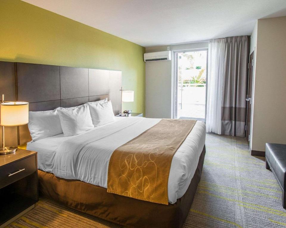 a hotel room with a large bed and a window at Comfort Suites Miami Airport North in Miami