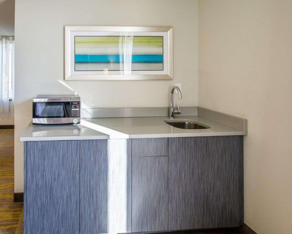 a kitchen with a sink and a microwave on a counter at Comfort Suites Miami Airport North in Miami