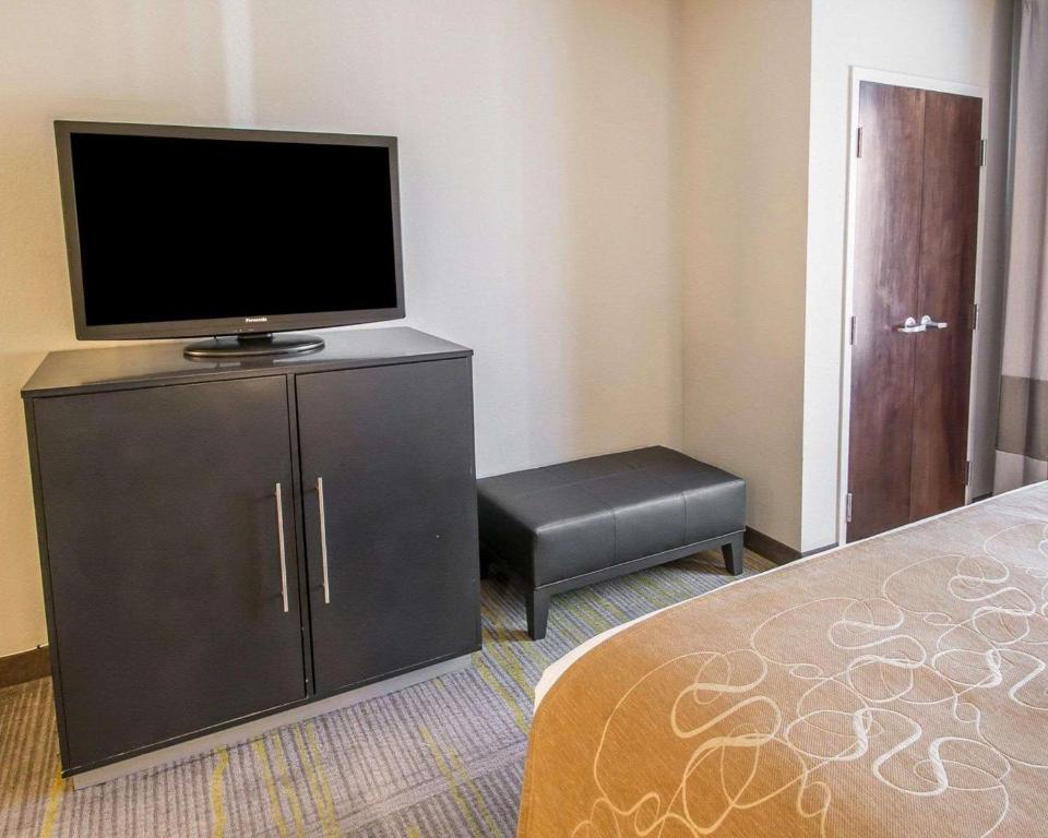 a bedroom with a flat screen tv on a dresser at Comfort Suites Miami Airport North in Miami