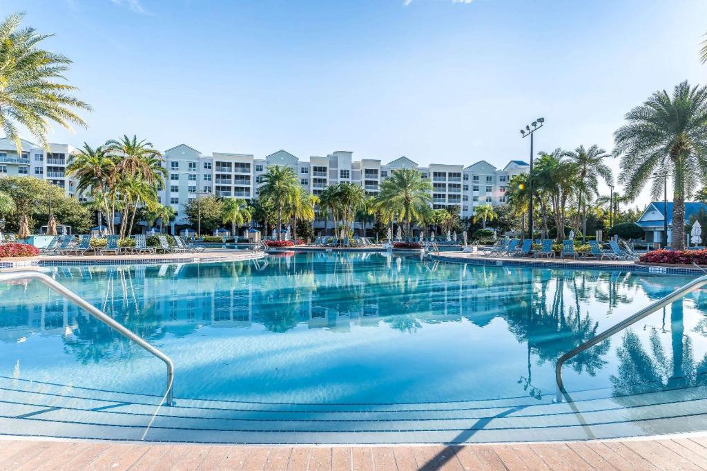 une grande piscine avec des palmiers et des bâtiments dans l'établissement Bluegreen Vacations The Fountains, Ascend Resort Collection, à Orlando