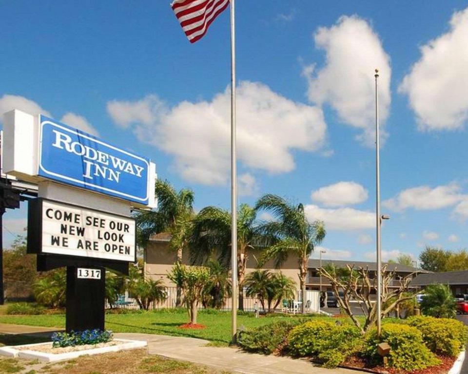 een bord voor een Roelandse herberg met een Amerikaanse vlag bij Rodeway Inn Apopka in Orlando