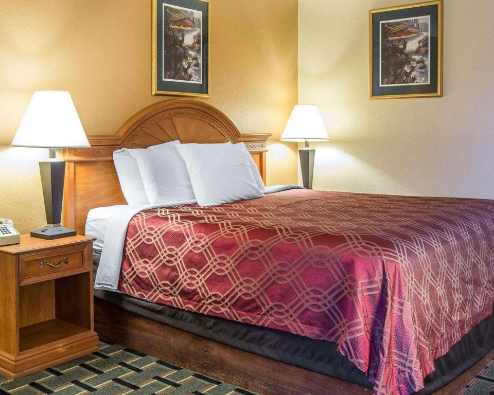 una camera d'albergo con un grande letto con due lampade di Econo Lodge Dalton West a Dalton