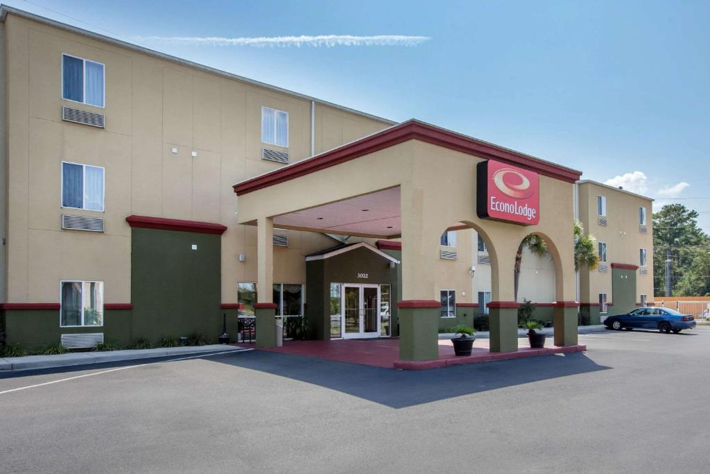 a hotel with a car parked in a parking lot at Econo Lodge in Valdosta