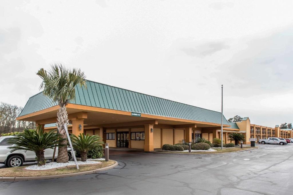 a building with a palm tree in a parking lot at Quality Inn Midtown Savannah in Savannah