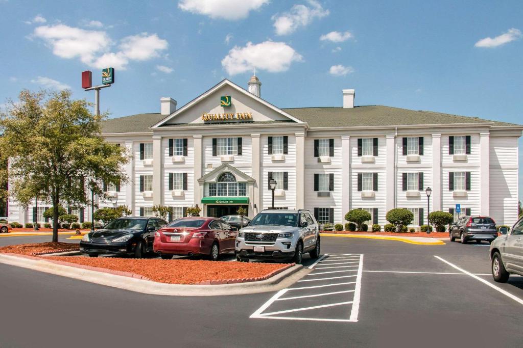 un grande edificio bianco con auto parcheggiate in un parcheggio di Quality Inn Pooler - Savannah I-95 a Savannah