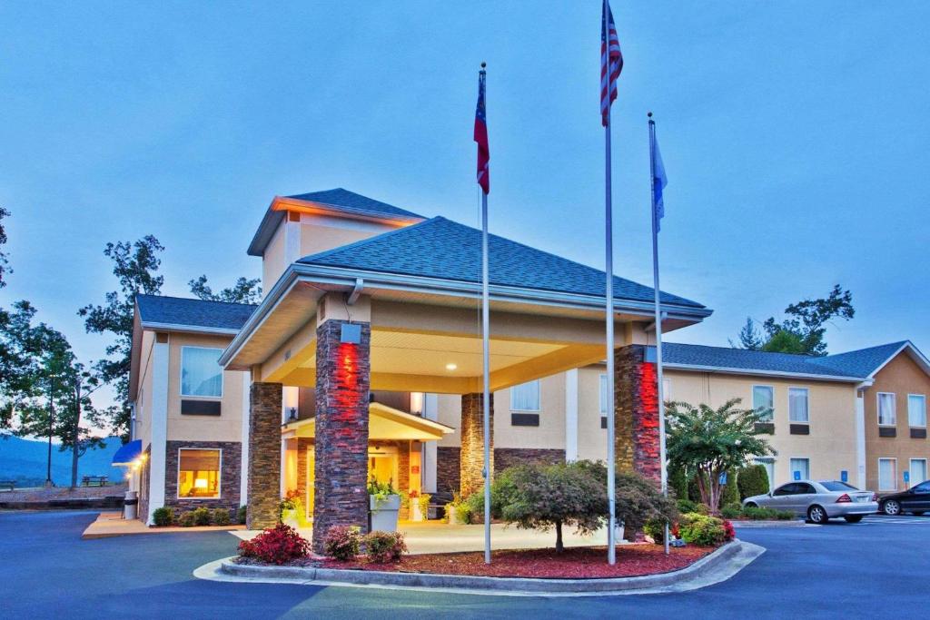 un hotel con banderas en un estacionamiento en Comfort Inn Blairsville, en Blairsville