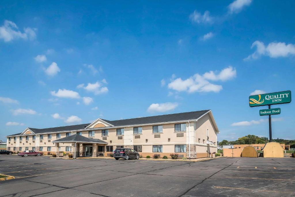 un grand bâtiment avec une voiture garée dans un parking dans l'établissement Quality Inn Coralville - Iowa River Landing, à Coralville