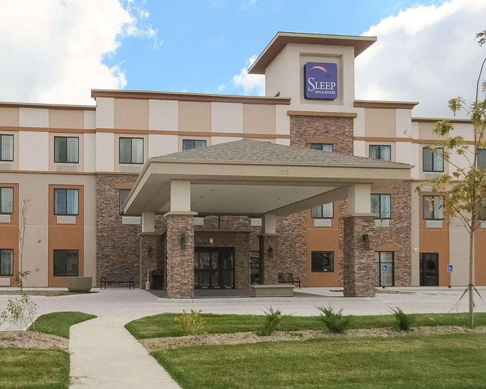 a hotel building with a sign on top of it at Sleep Inn & Suites Fort Dodge in Fort Dodge