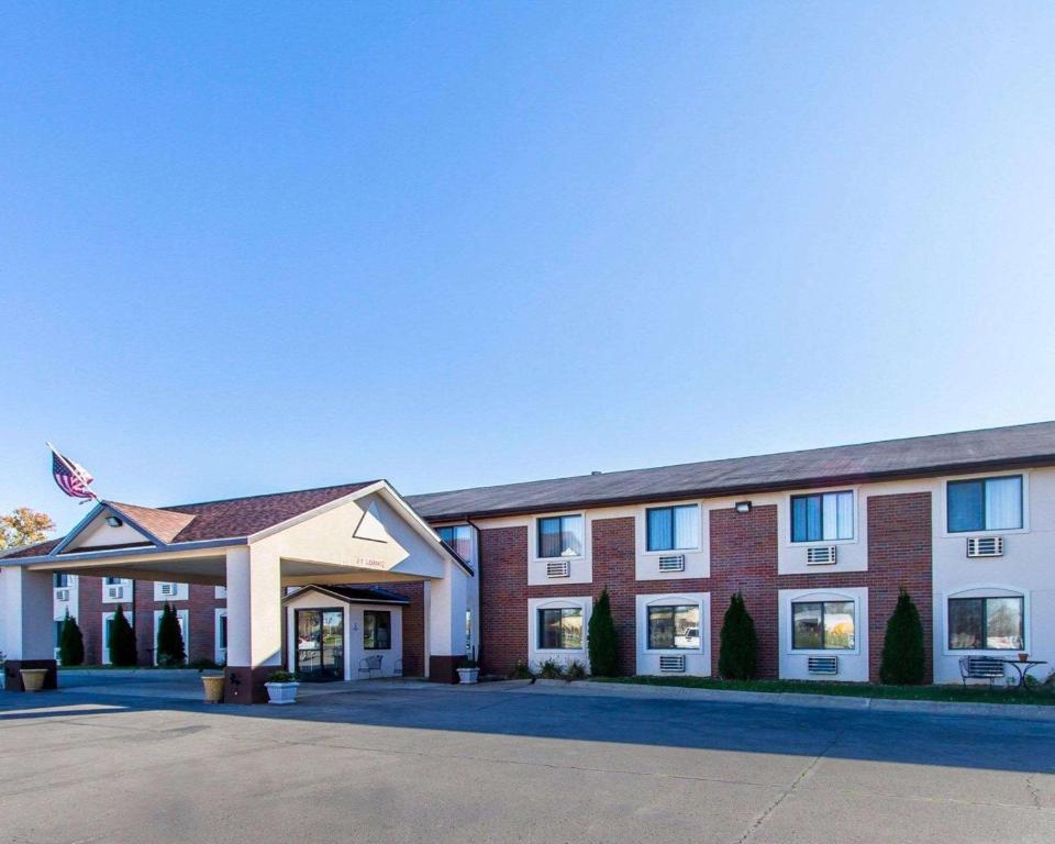 un grand bâtiment avec un drapeau américain devant dans l'établissement Quality Inn & Suites Ottumwa, à Ottumwa