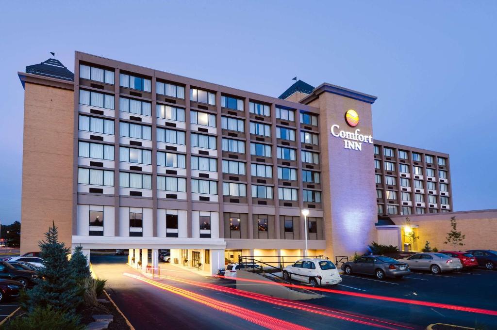 un bâtiment d'hôtel avec des voitures garées dans un parking dans l'établissement Comfort Inn & Suites Event Center, à Des Moines