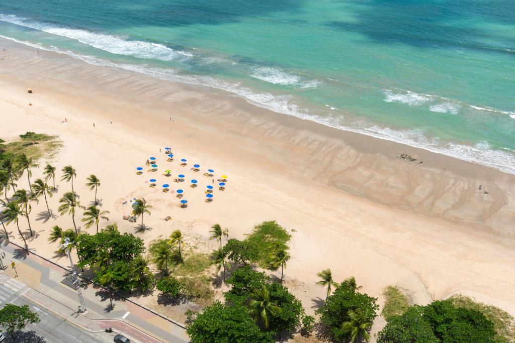 an overhead view of a beach with a group of umbrellas at Excelente Flat Beira Mar da praia de Boa Viagem RAD2704 in Recife