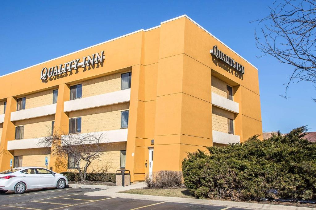 a building with a car parked in front of it at Quality Inn Elgin I-90 in Elgin