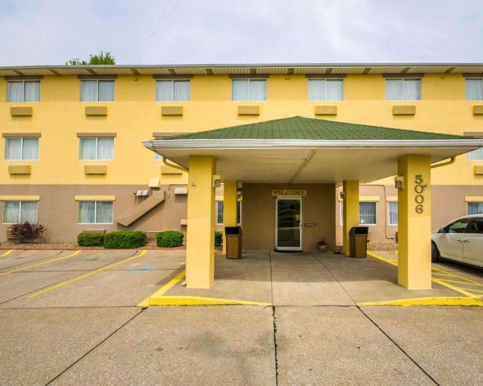 um edifício amarelo com um parque de estacionamento em frente em Quality Inn East Evansville em Evansville