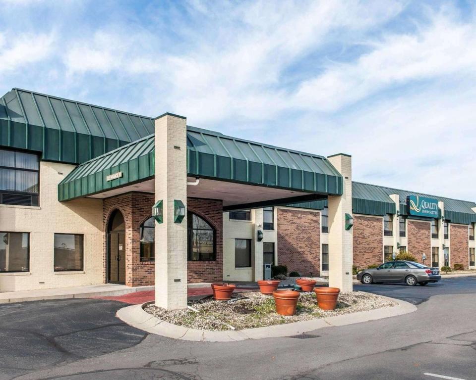 シェルビービルにあるQuality Inn & Suites Shelbyville I-74の駐車場内の緑日焼け付きの建物