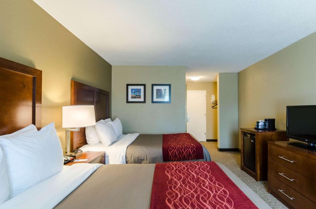 a hotel room with two beds and a flat screen tv at Comfort Inn Randolph-Boston in Randolph