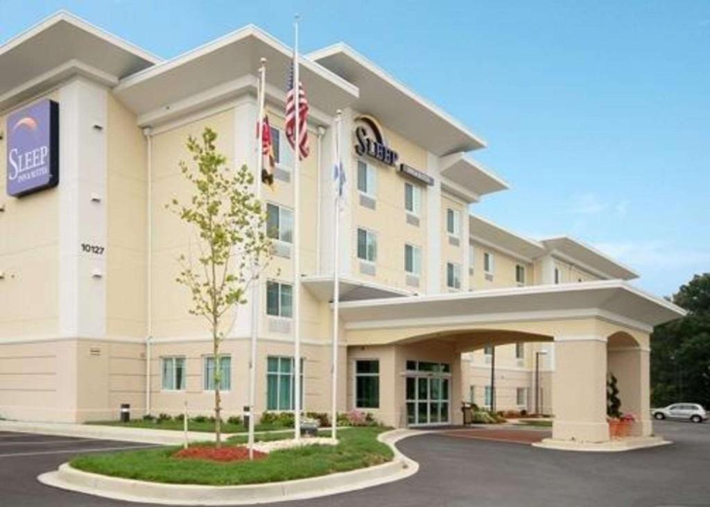 um hotel com uma bandeira americana em frente em Sleep Inn & Suites em Laurel