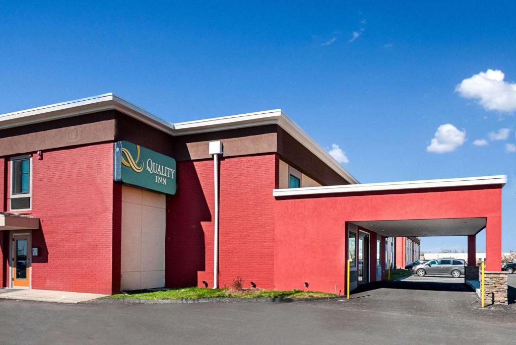 a red building with a garage with a car in it at Quality inn near Pimlico Racetrack in Baltimore