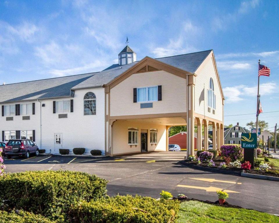 a large white building with an american flag at Quality Inn & Suites in South Portland