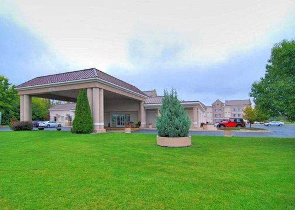 a large house with a green lawn in front of it at Comfort Inn in Birch Run