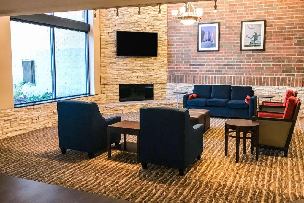 a lobby with a couch and chairs and a fireplace at Comfort Inn in Farmington Hills