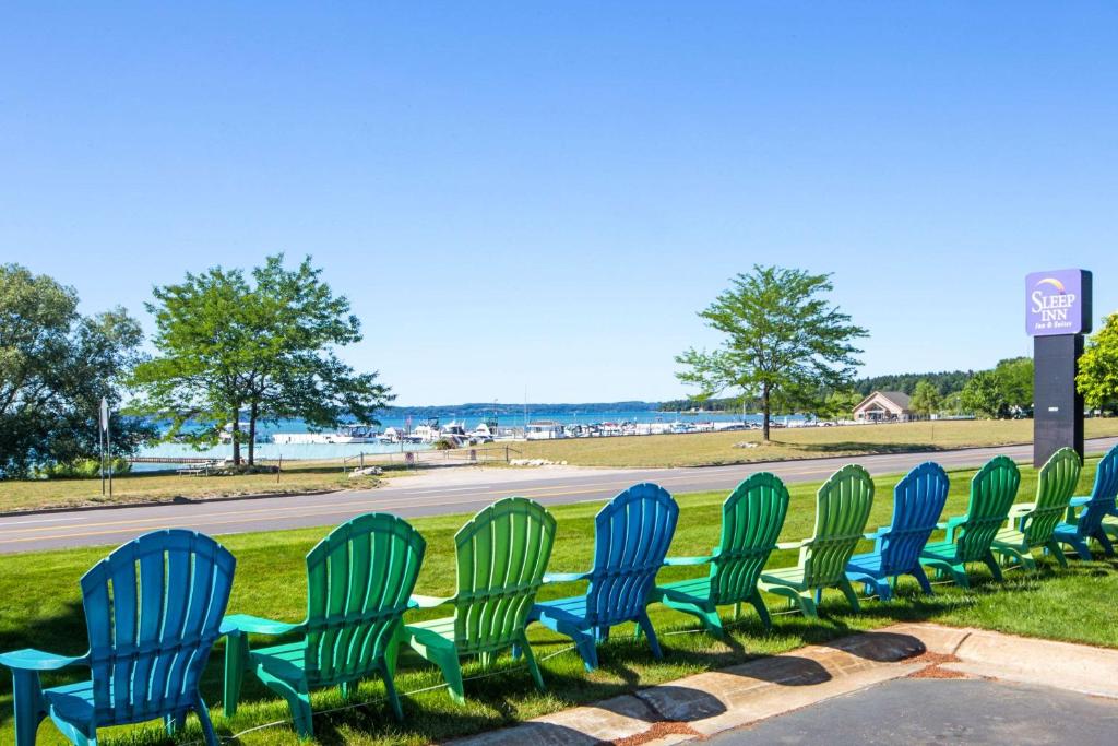 eine Reihe von grünen Stühlen, die auf einer Straße sitzen in der Unterkunft Sleep Inn & Suites Bay View Acme - Traverse City in Traverse City