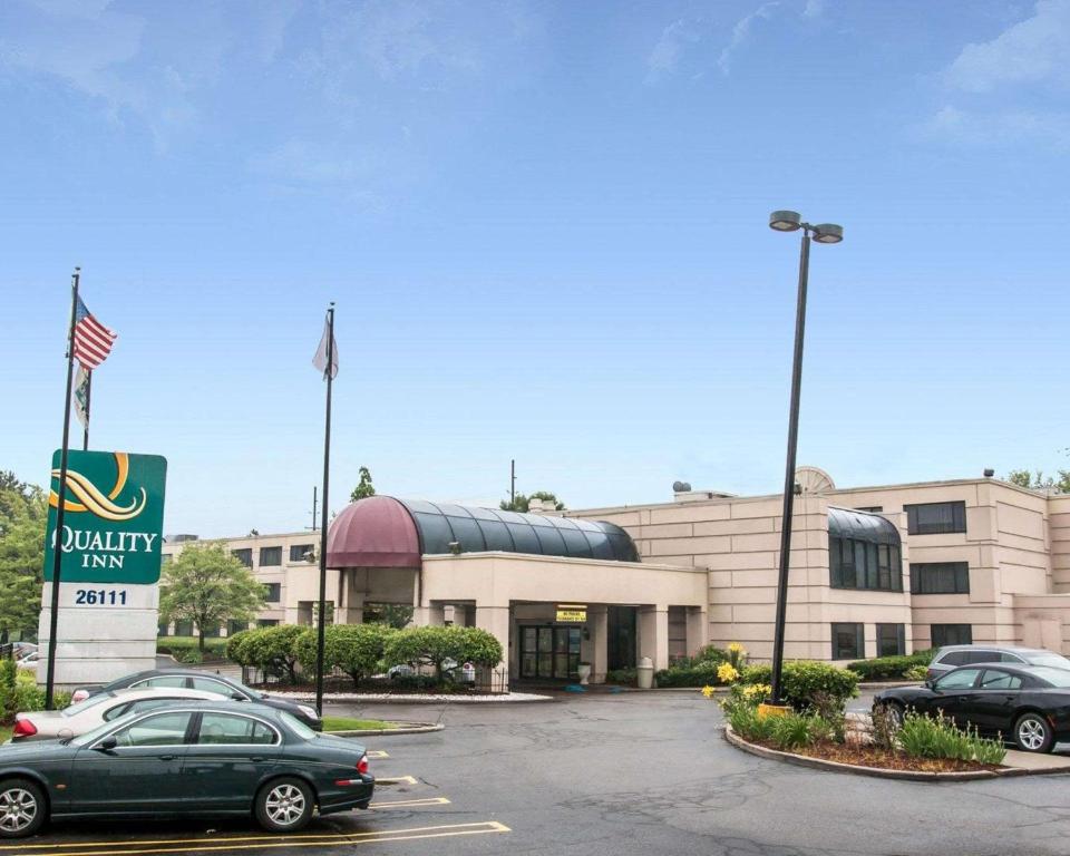 un estacionamiento con autos estacionados frente a un edificio en Quality Inn Southfield, en Southfield