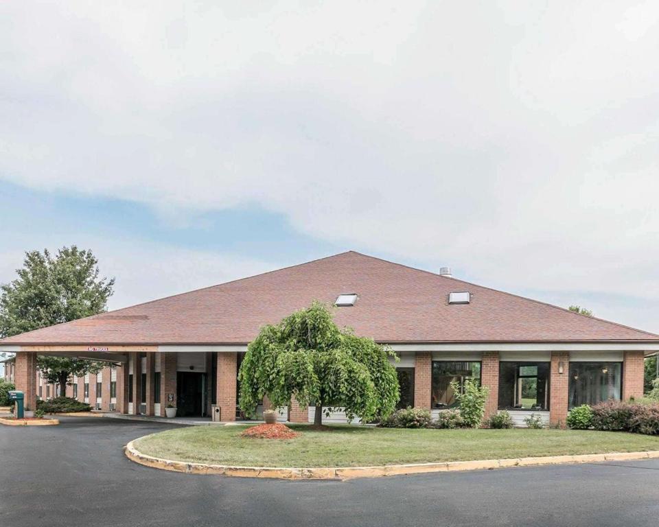 a large brick building with a road in front of it at Quality Inn Grand Rapids North in Grand Rapids