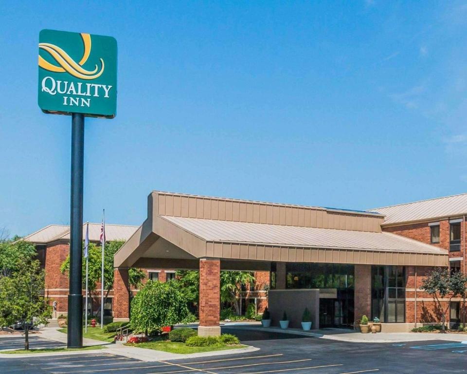 uma placa de pousada de qualidade em frente a um edifício em Quality Inn Auburn Hills em Auburn Hills