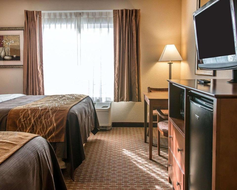a hotel room with two beds and a flat screen tv at Quality Inn Near Interstate I94 in New Buffalo