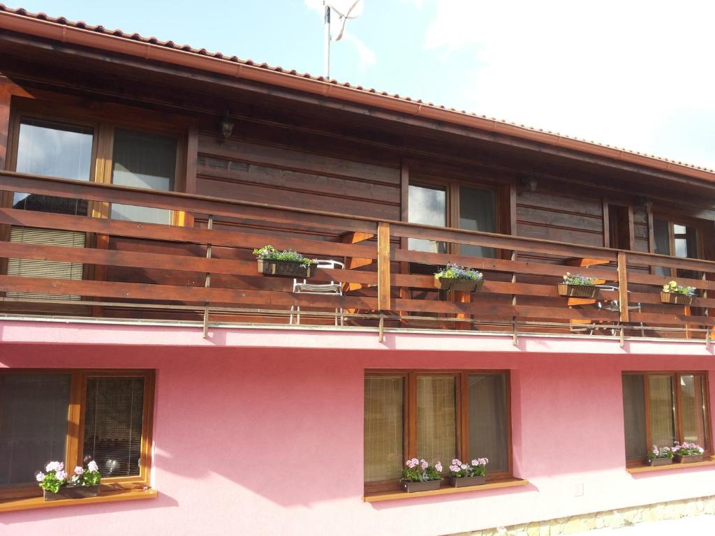 un edificio con balcones de madera y macetas de flores. en Apartmany Danka, en Pavčina Lehota