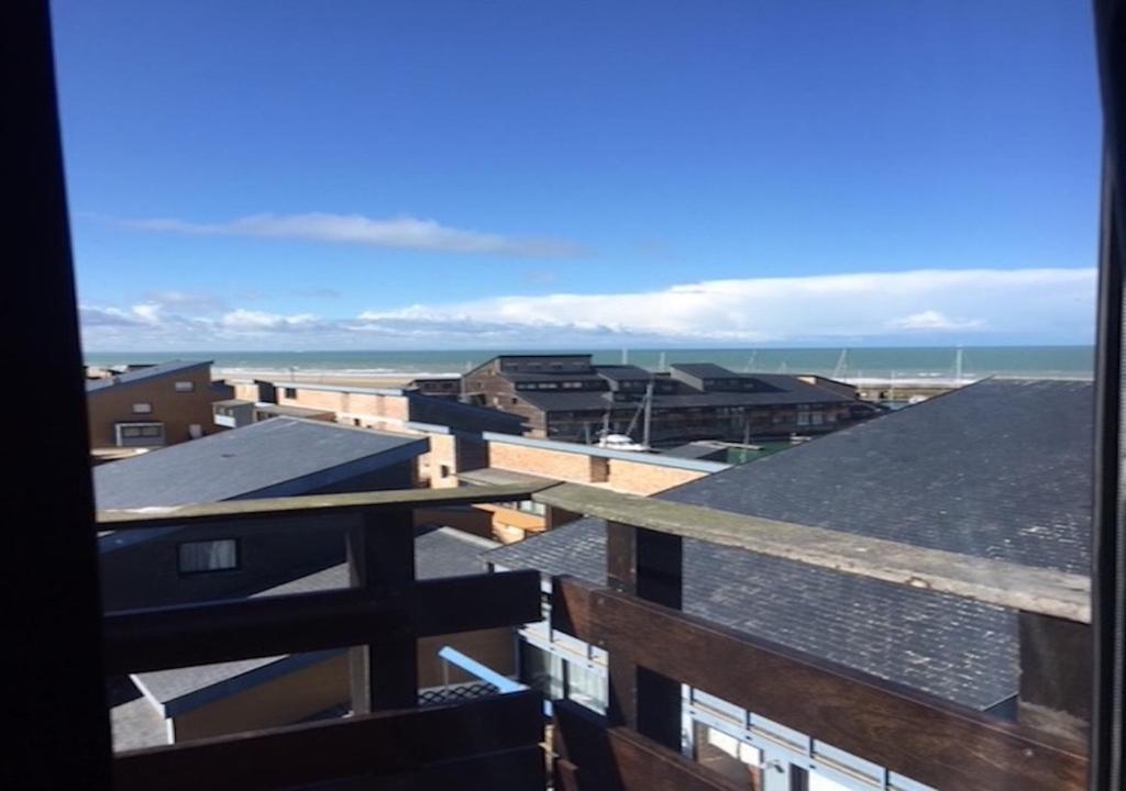 uma vista para o oceano a partir da varanda de um edifício em Mini DUPLEX VUE MER EXPOSITION SUD em Deauville