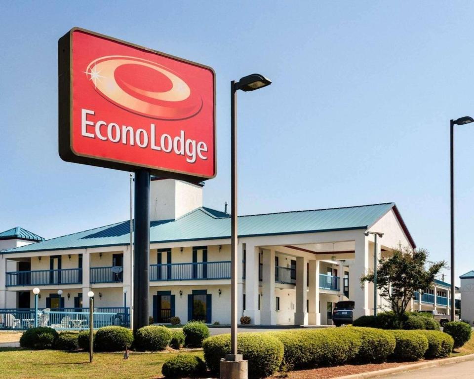 un cartello di fronte a un edificio con un motel corona di Econo Lodge Canton I-55 a Canton