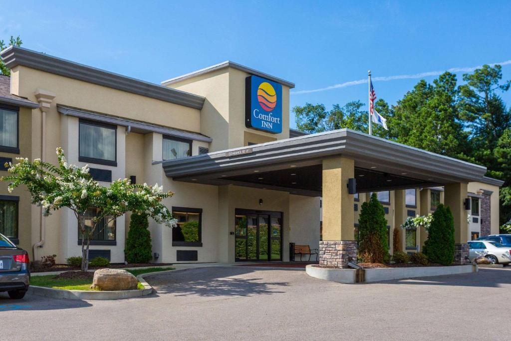 a hotel with an american flag in a parking lot at Comfort Inn in Tupelo