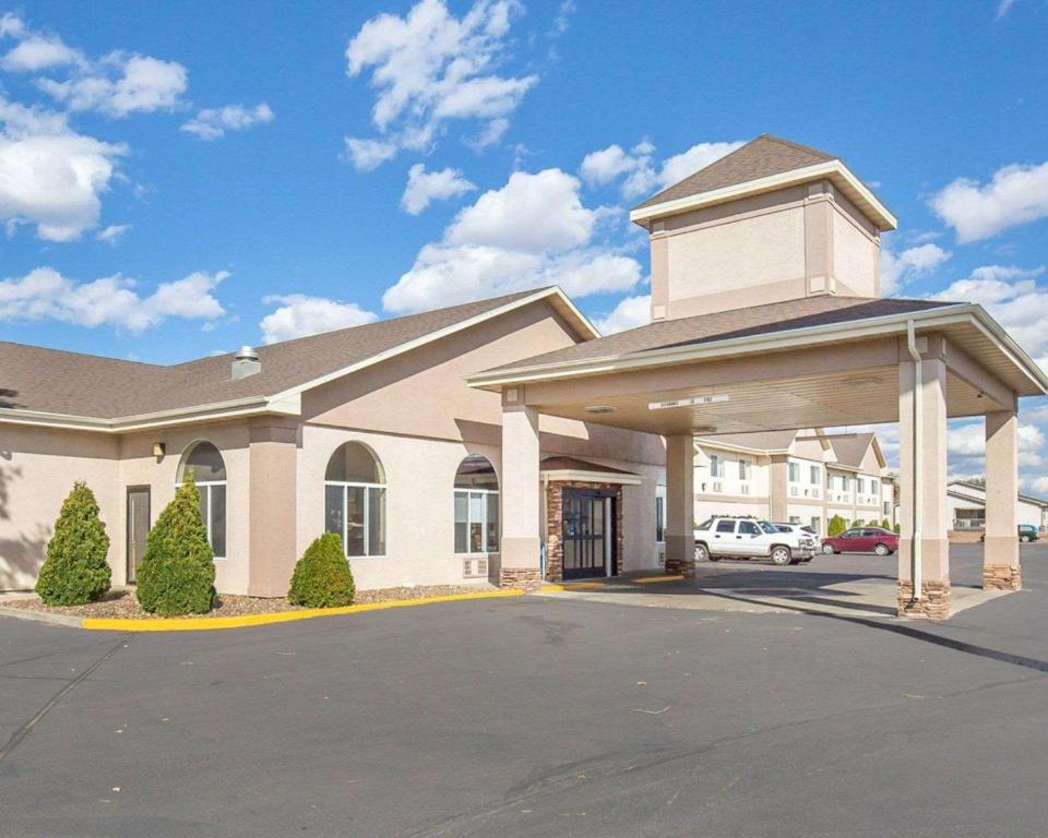 a large building with a garage in a parking lot at FairBridge Inn & Suites Glendive in Glendive