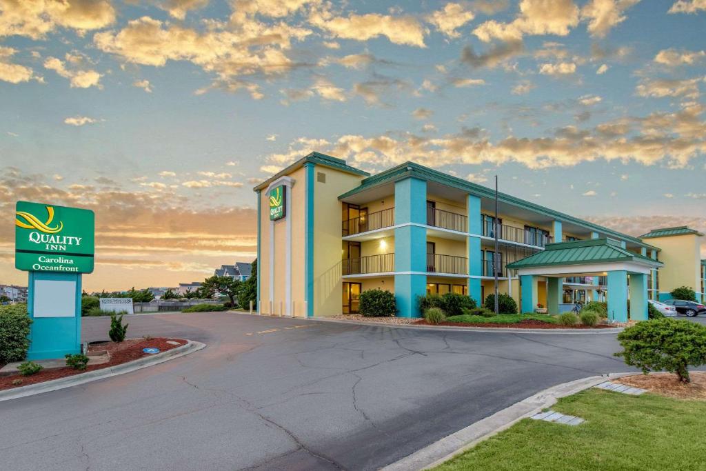 Quality Inn Carolina Oceanfront في كيل ديفيل هيلز: فندق فيه لافته امام مبنى