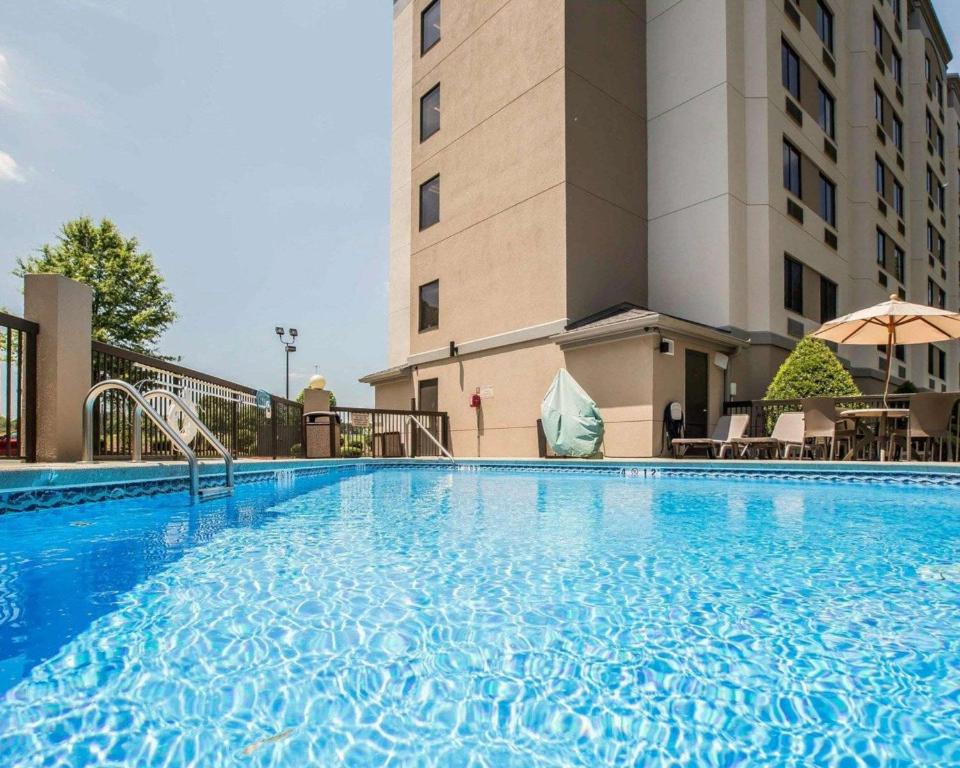 a large swimming pool in front of a hotel at Sleep Inn Airport in Greensboro