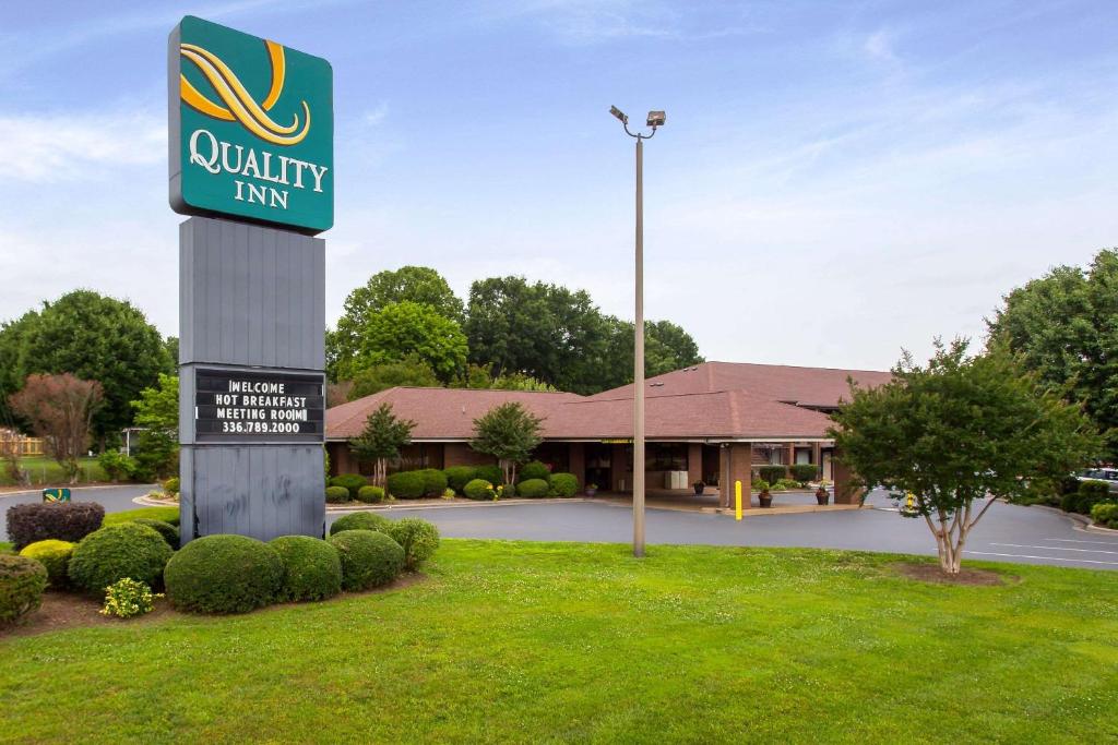 una señal para una posada de calidad frente a un edificio en Quality Inn Mount Airy Mayberry, en Mount Airy