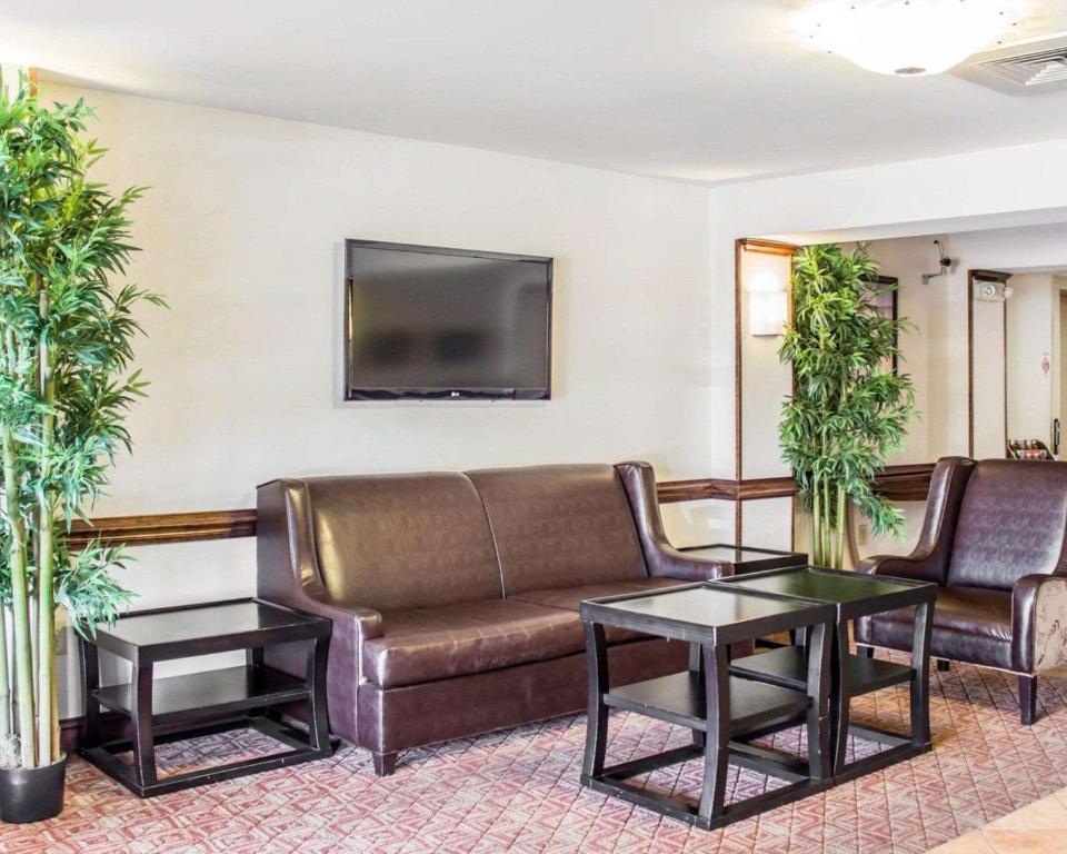 a living room with a couch and a tv at Quality Inn Raleigh Downtown in Raleigh