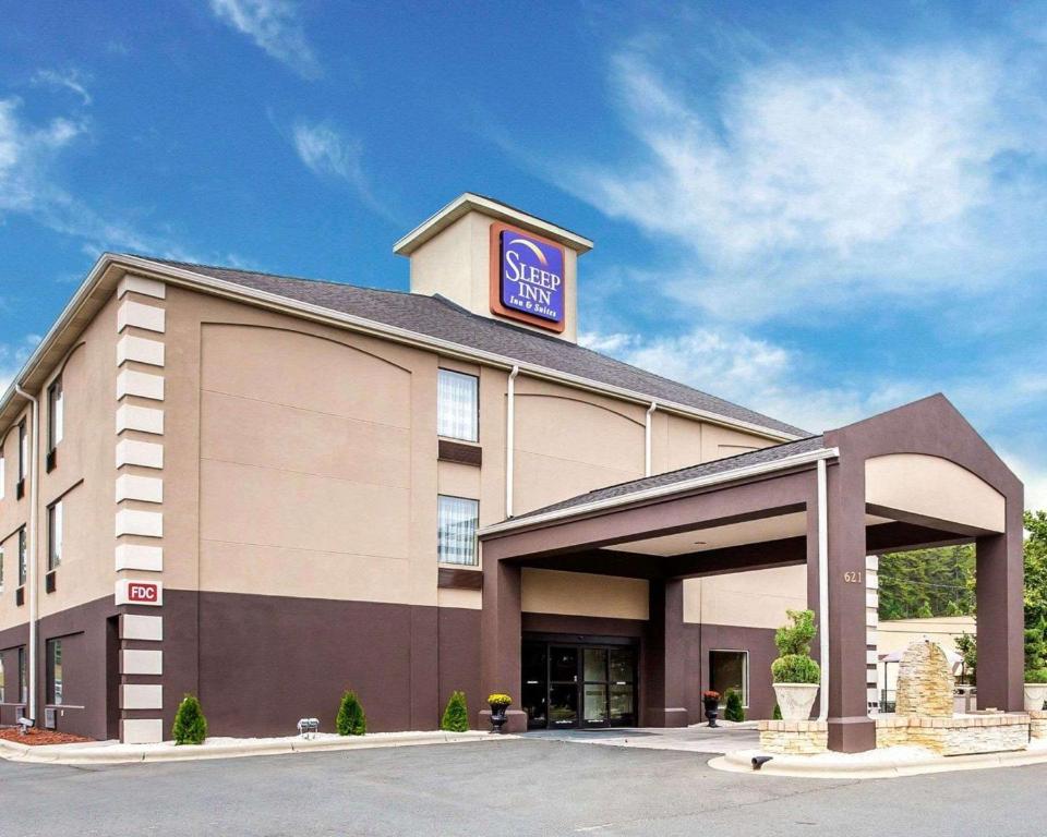 a hotel with a sign on top of it at Sleep Inn & Suites Albemarle in Albemarle