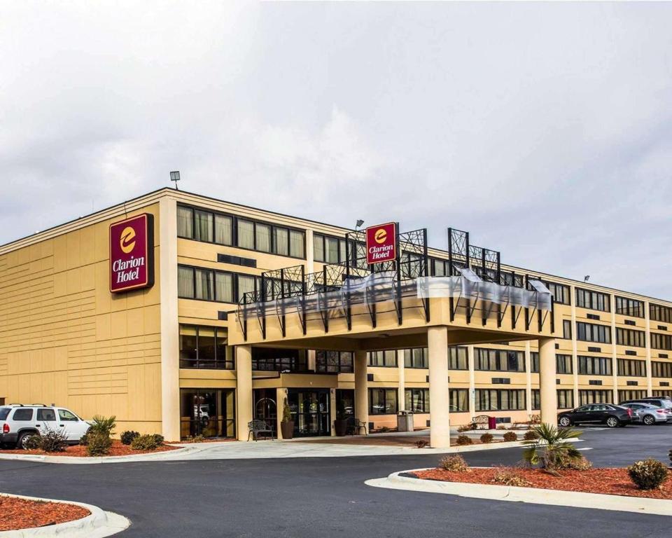 a large building with a balcony in a parking lot at Clarion Hotel Charlotte Airport & Conference Center in Charlotte