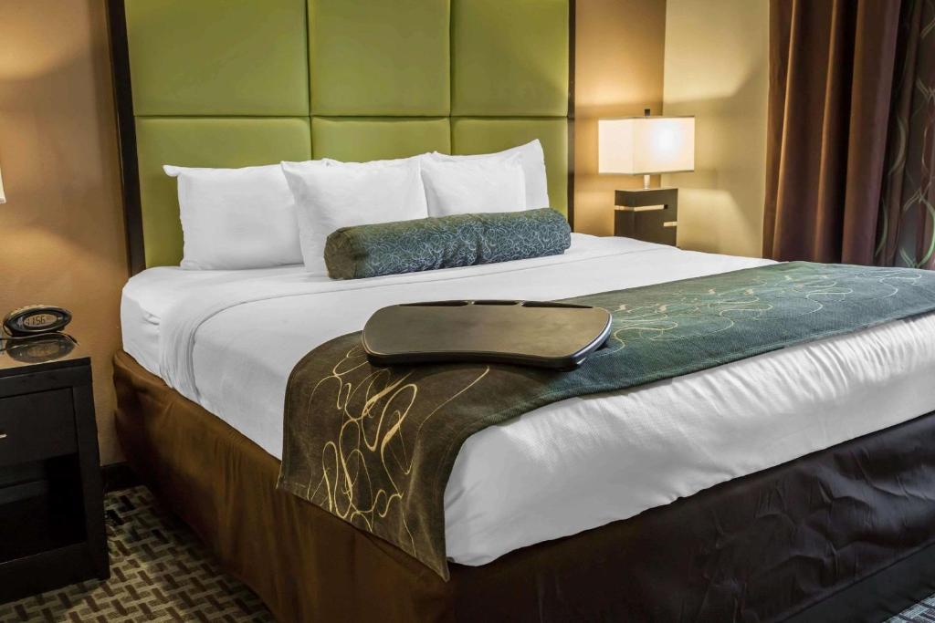 a hotel room with a large bed with a bag on it at Comfort Suites New Bern near Cherry Point in New Bern
