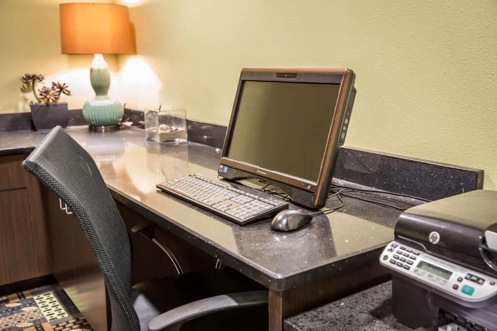a desk with a computer monitor and a keyboard and mouse at Comfort Suites New Bern near Cherry Point in New Bern