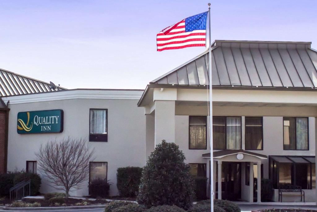 una bandera americana ondeando frente a un hotel en Quality Inn & Suites Wilson, en Wilson