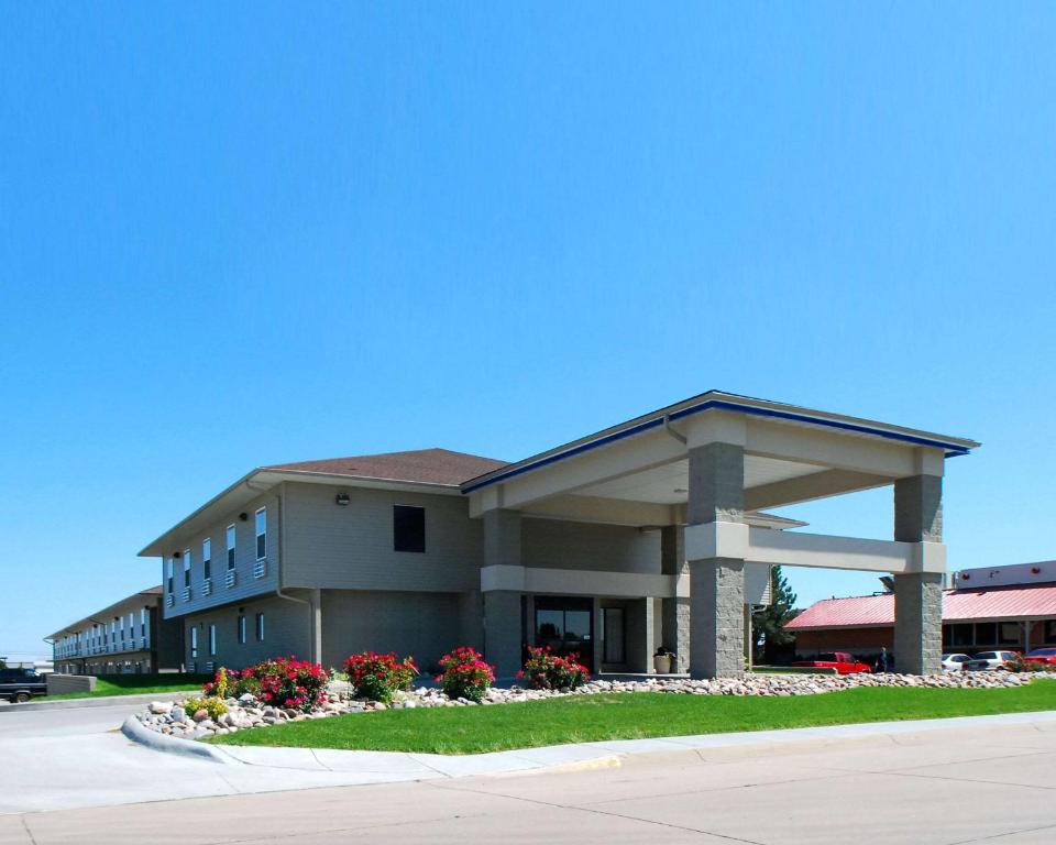 a large building with flowers in front of it at Econo Lodge Inn & Suites in Kearney