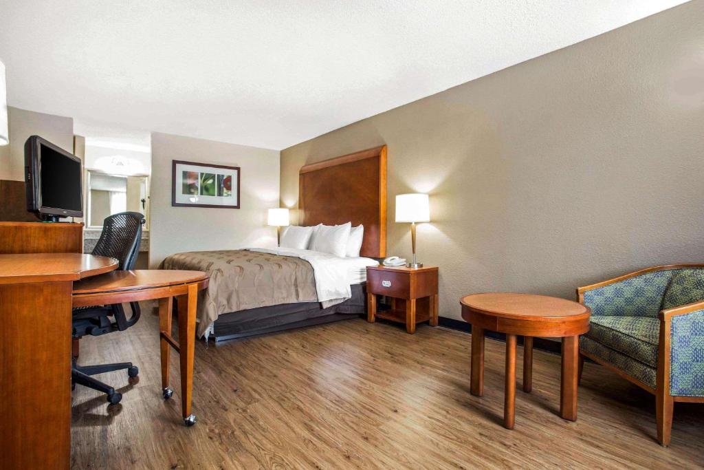 a hotel room with a bed and a desk and a computer at Quality Inn & Suites University Area in Charlotte