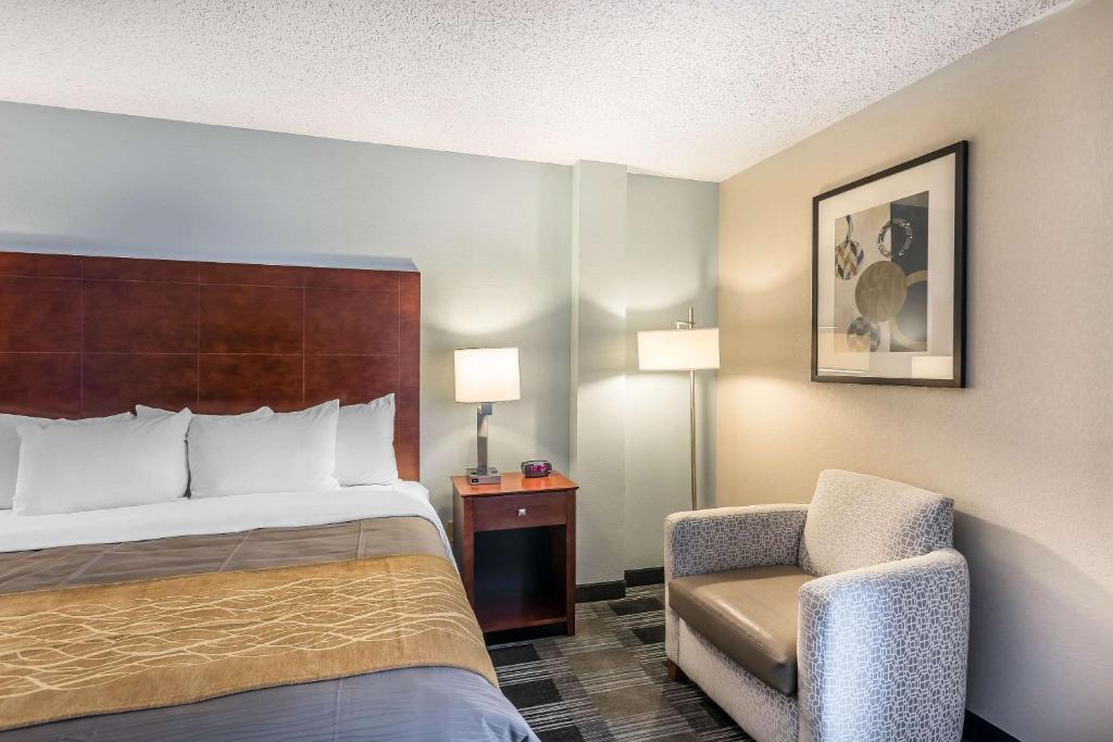 a hotel room with a bed and a chair at Comfort Inn SW Omaha I-80 in Omaha