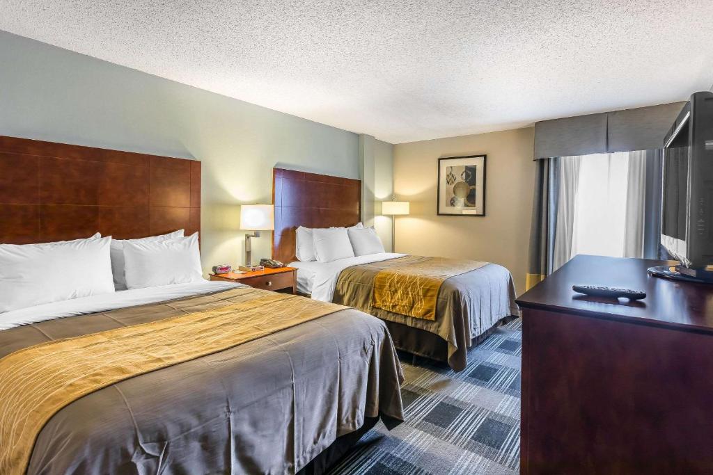 a hotel room with two beds and a flat screen tv at Comfort Inn SW Omaha I-80 in Omaha